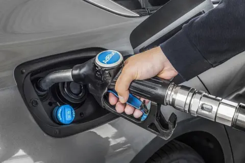 Persona repostando AdBlue en su coche. Averigua cuanto AdBlue consume un coche para optimizar tu viaje.