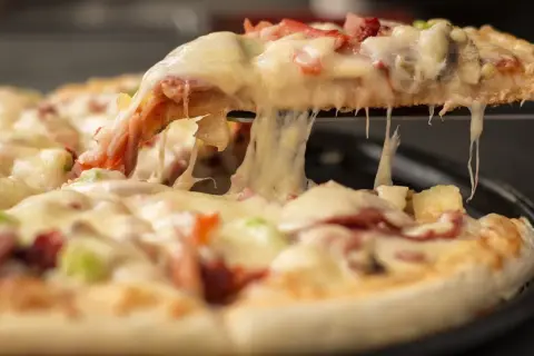 Rozciągający się ser z kawałka pizzy, idealny na festiwal pizzy.