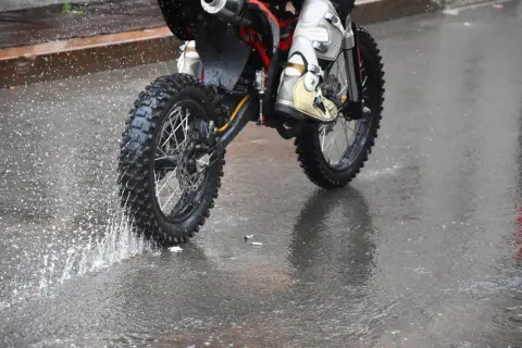 Niezwykła jazda motocyklem w deszczu. Błoto i woda rozpryskują się spod kół, tworząc widowiskowy pokaz.