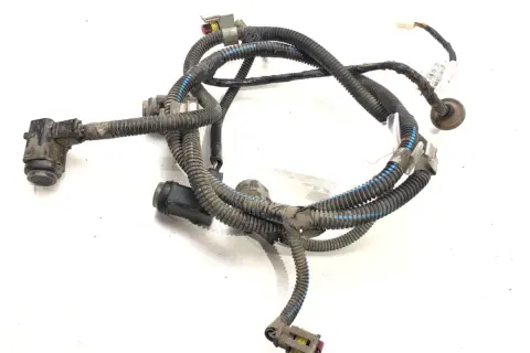 Uszkodzona wiązka czujników PDC w zderzaku. Widoczne czujniki i przewody w osłonach.