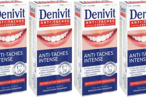 Cztery opakowania pasty do zębów Denivit Anti-Stain Expert z białym uśmiechem.
