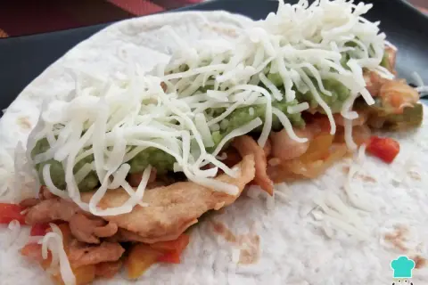 Fajitas de pollo y queso, con guacamole y pimientos salteados, envueltas en tortilla.
