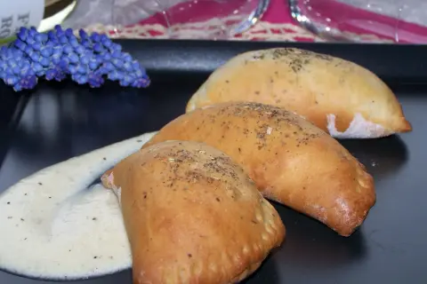 Pyszne pierożki z ciasta drożdżowego, posypane ziołami, podane z kremowym sosem. Idealne, gdy zastanawiasz się, co zrobić z drożdży.