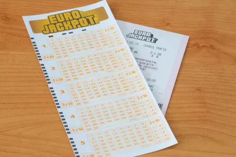Kupon Eurojackpot na drewnianym blacie. Zastanawiasz się, ile trwa losowanie Eurojackpot? Sprawdź swoje szczęśliwe liczby!