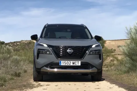 Grå Nissan X-Trail står på en grusväg. En potentiell nissan x-trail problem kan vara att den fastnar i terrängen.