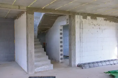 Wnętrze budowy z betonowymi schodami i otwartym przejściem. Jaki otwór pod drzwi 80 cm będzie idealny do tego pomieszczenia.