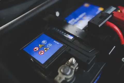 Bilbatteri med varningssymboler. Ett dåligt bilbatteri symptom kan vara att bilen inte startar.