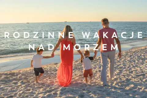 Rodzina spaceruje po plaży w Sarbinowie nad morzem. Słońce zachodzi, tworząc złote światło na piasku i wodzie.