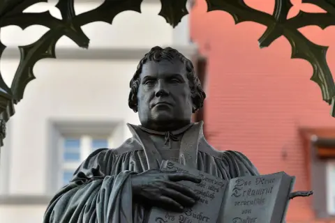 Bronzestatue von Martin Luther, der auf der Wartburg das Neue Testament hält.