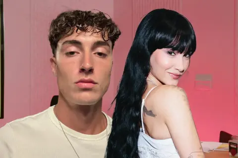 Plex y Aitana, dos jóvenes con miradas intensas, posan juntos en un estudio con fondo rosa.