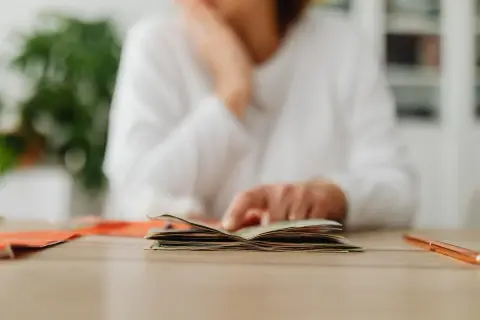 Osoba przegląda pieniądze, zastanawiając się nad wpływem stóp procentowych a inflacji na domowy budżet.