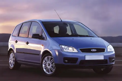 Niebieski Ford Focus C-Max z 2004 roku stoi na tle zachodzącego słońca.