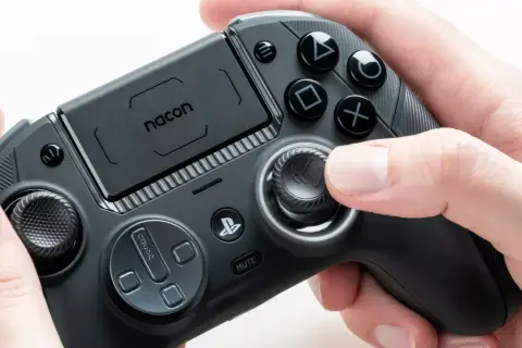 Ein Nacon-Controller, der für PS4 und PS5 geeignet ist, wird von Händen gehalten.
