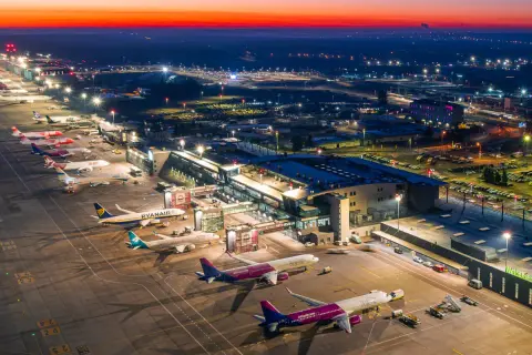 Lotnisko Katowice-Pyrzowice nocą, z samolotami na płycie i oświetlonym terminalem. Rozkład lotów pyrzowice jest dynamiczny.