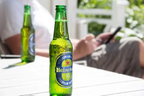 Butelka Heineken 0.0 na stole. Zastanawiasz się, ile kalorii ma piwo? To piwo bezalkoholowe ma ich niewiele.