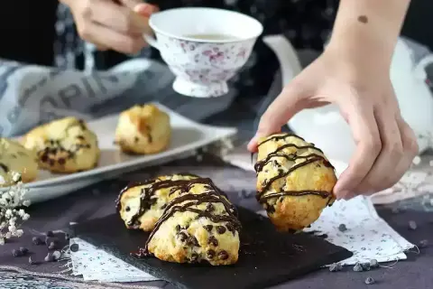 Färska scones med chokladbitar, redo att avnjutas med en kopp te. Perfekt för att baka scones en mysig eftermiddag.