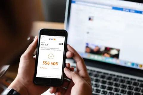 Oszustwo na BLIK: kod 356 406 na ekranie telefonu, obok laptop z otwartym Facebookiem.