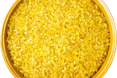 Żółta kasza bulgur w ceramicznej misce. Idealna do przygotowania pysznego posiłku, np. jak ugotować kaszę bulgur w woreczku.