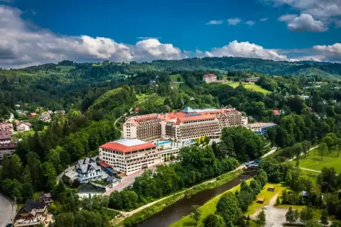Widok z lotu ptaka na rozległy hotel Gołębiewski w otoczeniu zielonych wzgórz i rzeki. Czy to jedyny hotel Gołębiewski w Polsce?