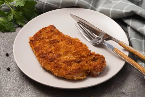 Złocisty kotlet schabowy na talerzu, gotowy do zjedzenia. Zastanawiasz się nad kotlet schabowy kcal?