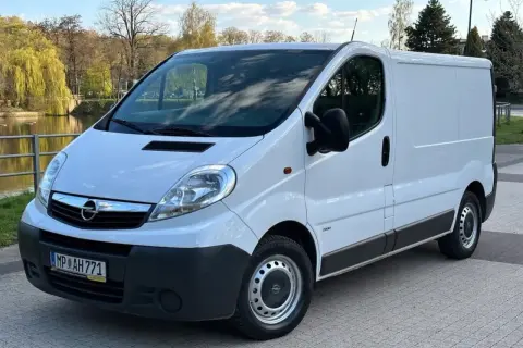 Biały Opel Vivaro 2.0 CDTI zaparkowany przy wodzie, gotowy do podróży.