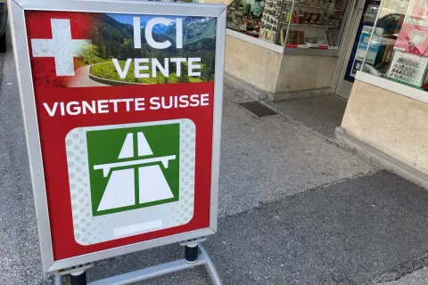 Panneau "Ici vente vignette suisse" avec un paysage alpin. Idéal pour votre séjour de 10 jours en Suisse.