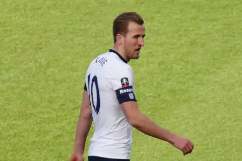 Piłkarz Harry Kane w białej koszulce z numerem 10. Zastanawiasz się, ile lat ma Harry Kane?