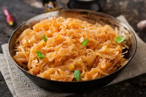 Pyszny bigos wegetariański w misce, ozdobiony listkami mięty. Aromatyczne danie z kapusty i warzyw.