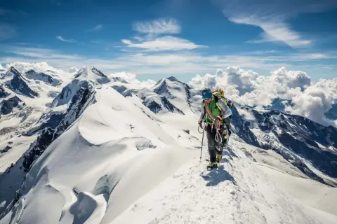 Bergsteiger auf einem schneebedeckten Grat, die Aussicht ist wie eine spaghetti runde.