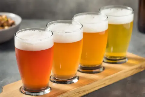 Quattro bicchieri di birra di diversi colori, un assaggio che racconta la storia della birra.