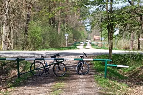 Dwa rowery czekają na odkrycie tras rowerowych Tarnów. Leśna droga zamykana szlabanem zaprasza do przygody.