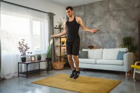 Man doing jump rope workout at home, a great alternative to burpees for cardio.