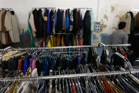 Perchate tesoros en el mercadillo vintage Zaragoza. Ropa de segunda mano colgada en percheros, esperando ser descubierta.