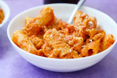 Ein Teller Rigatoni mit cremiger Tomatensoße und Parmesan, ein Klassiker des Neapel Essens.