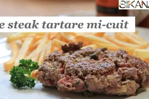 Un steak tartare mi-cuit, savoureux et juteux, servi avec des frites croustillantes et une touche de persil frais. Un délice pour les amateurs de viande.