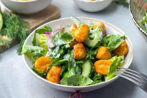 Knuspriger Gnocchi Salat mit Gurken, Zwiebeln und cremigem Dressing. Ein leckeres Gericht für jede Gelegenheit.