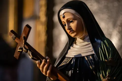 Figurka świętej Rity od spraw beznadziejnych trzyma krzyż.