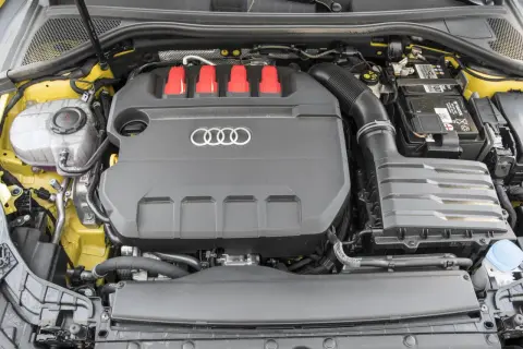 Silnik 2.0 TFSI z czerwonymi elementami i logo Audi. Widoczny akumulator i zbiornik płynu.