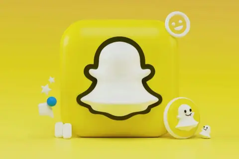 Ikona Snapchata z małymi duchami i emotikonami na żółtym tle.