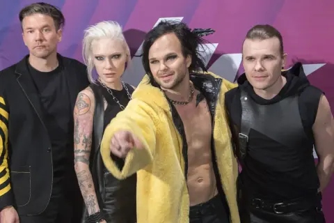 Zespół The Rasmus na koncercie, w tym wokalista Lauri Ylönen w żółtym futrze.