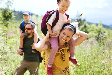 Familia disfrutando de benasque rutas sencillas. Niños a caballito, sonrisas y naturaleza.