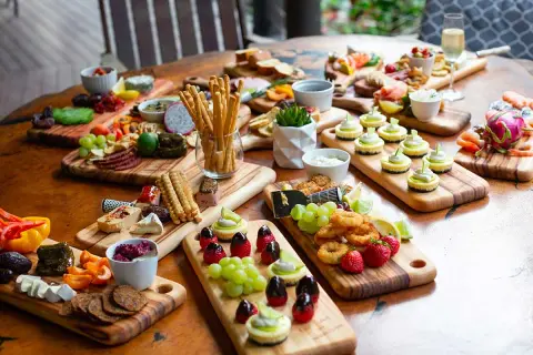 Plateaux variés pour un thème pour nouvel an : mini-cheesecakes, fruits, charcuterie, crevettes et grissini.