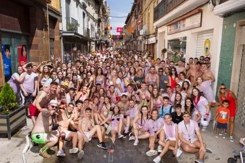 Multitud celebrando las fiestas de Zuera, con gente sonriendo y posando para la foto en una calle.