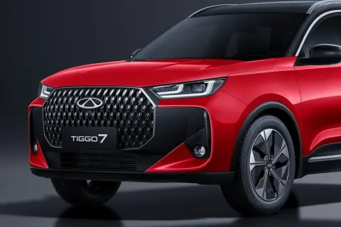 Czerwone auto Chery Tiggo 7 z czarnym dachem i felgami, prezentujące nowoczesny design i charakterystyczny grill.