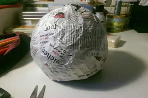 Papierkugel mit Zeitungspapier und Kleister. Die Frage, wie lange braucht Mehlkleister zum trocknen, beschäftigt den Bastler.