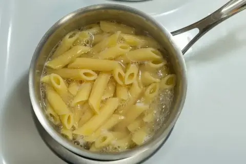 Penne rigate gotują się w garnku na kuchence.