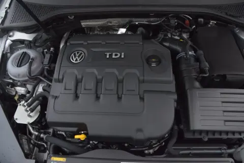 Silnik 2.0 TDI 190 KM. Widok na pokrywę silnika z logo VW i napisem TDI. W tle zbiornik płynu chłodniczego.
