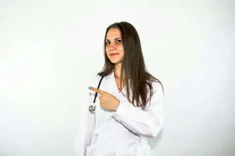 Lekarka w białym kitlu wskazuje palcem, sugerując, że warto rozważyć Locoid Lipocream na problemy skórne.