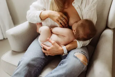 En mamma ammar sitt barn. Diskussioner om alkohol och amning är viktiga för att säkerställa barnets välmående.