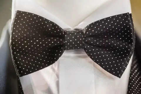 Czarna mucha w groszki, idealna do granatowego garnituru. Elegancki dodatek na specjalne okazje.